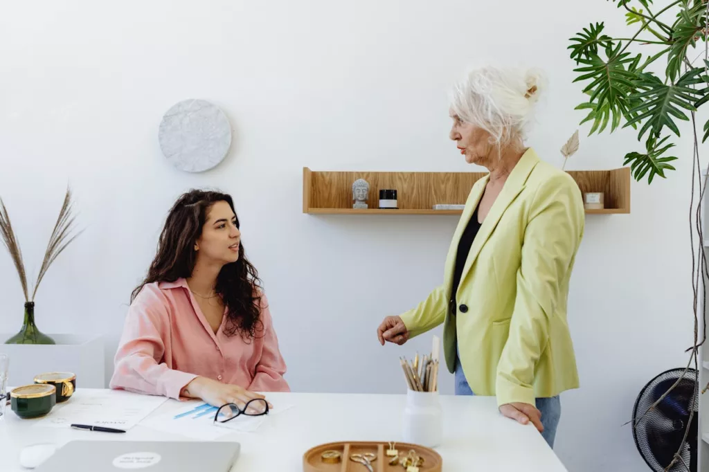 Deux femmes qui se parlent dans bureau